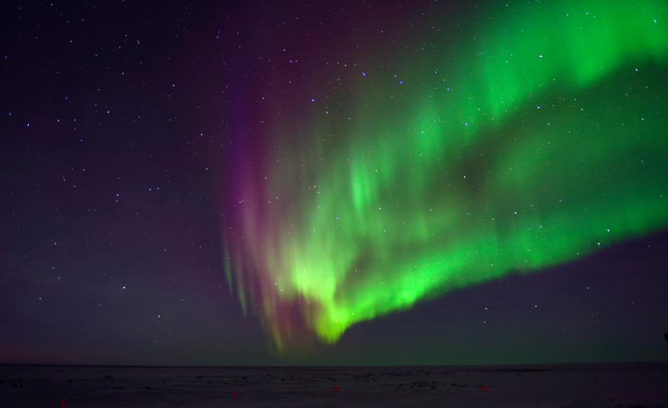 Je nachdem, ob Elektronen mit Sauerstoff oder Stickstoff kollidieren, ist das resultierende Licht entweder grÃ¼n oder rot, so dass die Aurora einen wirbelnden Vorhang aus verschiedenen Lichtfarben bildet.  Bild: Michael Wenger